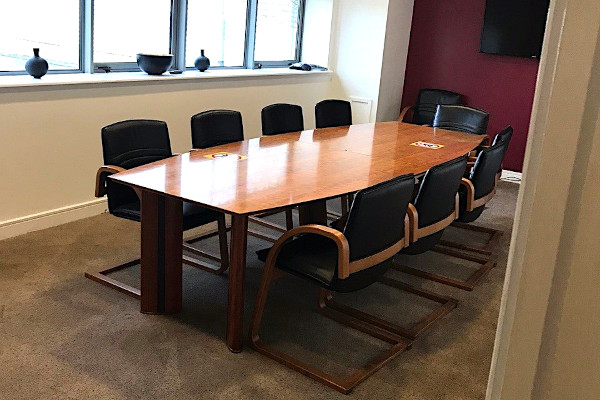 a clean board room with a large desk in the middle