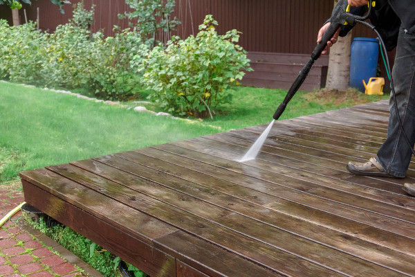 a person pressure washing an outside deck