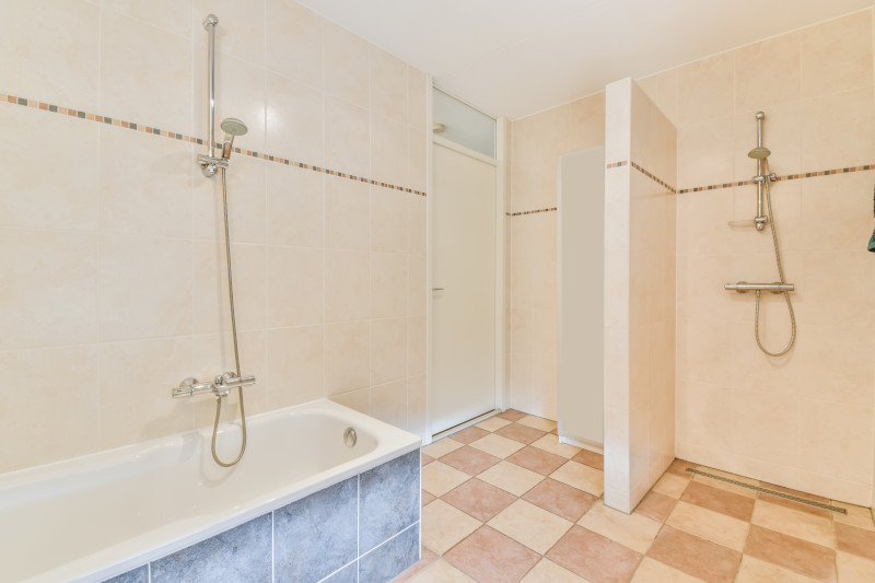 freshly cleaned bathroom terracotta floor with bath tub and shower